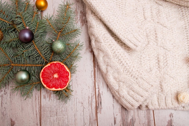 Concepto navideño de la rama de furtree de suéter de punto con bolas de abeto vista superior de pomelo