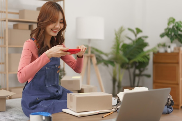 Concepto de negocio de compras en línea Mujeres empresarias toman una caja de productos fotográficos antes de la entrega al cliente