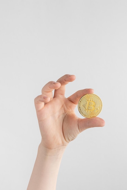 Concepto de negocio de criptomoneda de moneda Bitcoin de oro de mano de niño