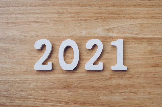 Concepto de negocio y diseño - número de madera 2021 para texto de feliz año nuevo en la mesa de madera.