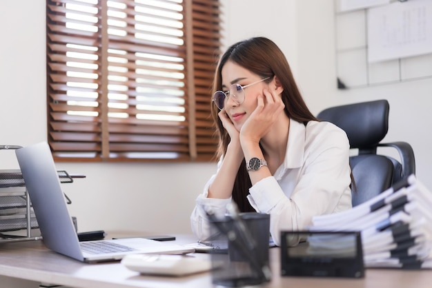 Concepto de negocio Empresaria está tocando la barbilla en las manos y leyendo datos comerciales en la computadora portátil