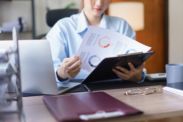 Foto concepto de negocio empresarias está leyendo y analizando documentos de datos financieros en el lugar de trabajo