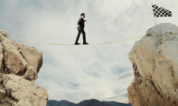 Foto concepto de negocio del empresario que supera los problemas para llegar a la meta con una cuerda