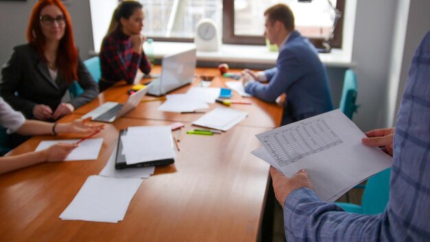 Concepto de negocio Un equipo de trabajo que tiene una conferencia Un hombre trae los documentos