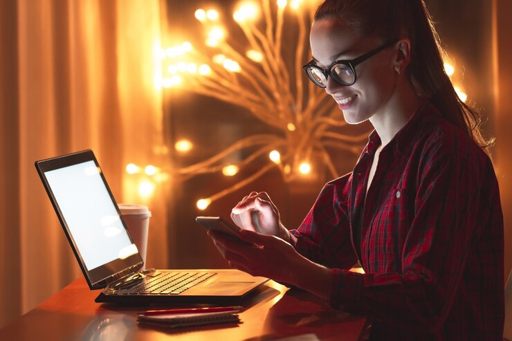 Foto concepto de negocio, exceso de trabajo, fecha límite y personas. mujer joven en gafas trabajando en línea usando la computadora portátil y teléfono tarde en casa. trabajador nocturno y nocturno