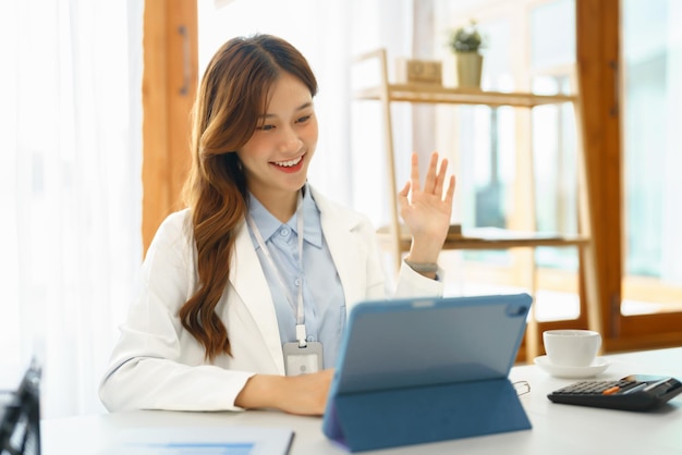 Concepto de negocio exitoso Mujer de negocios haciendo un gesto de saludo con un colega en una videollamada