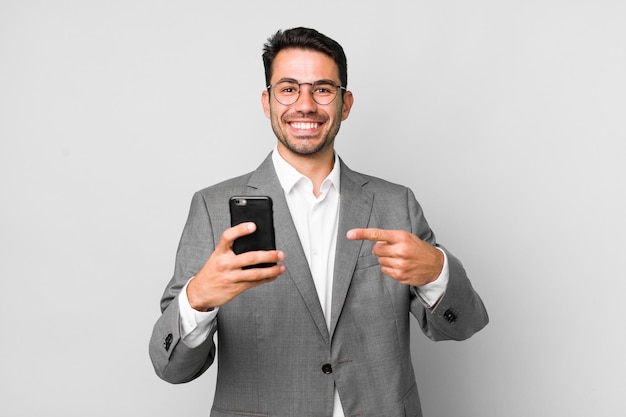 Concepto de negocio de hombre hispano guapo adulto joven con un teléfono móvil