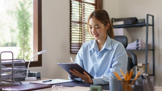 Concepto de negocio de inicio Empresarias escribiendo horario de trabajo en tableta mientras trabajan en el lugar de trabajo