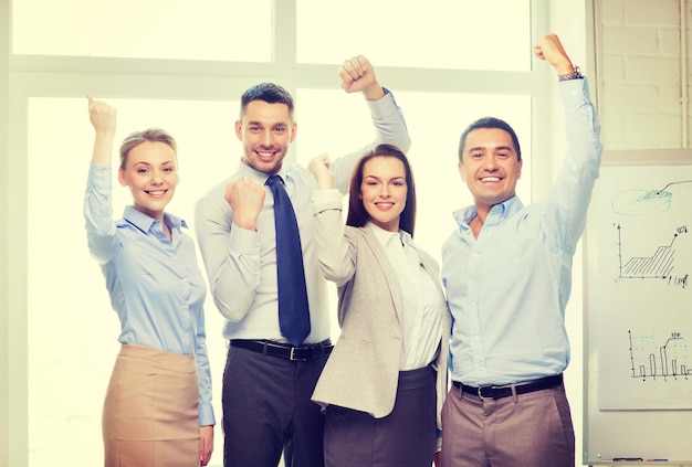 concepto de negocio, oficina, éxito y victoria - equipo de negocios feliz celebrando la victoria en el cargo