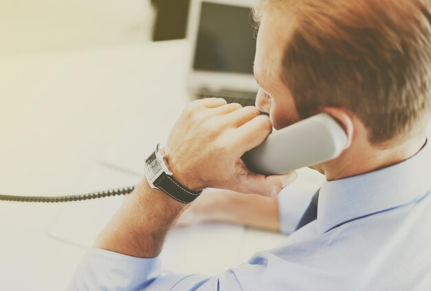 concepto de negocio y oficina - hombre de negocios hablando por teléfono