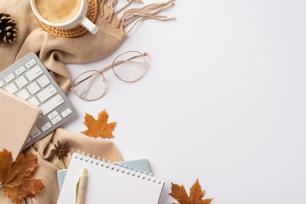 Concepto de negocio de otoño Foto de vista superior del espacio de trabajo teclado blocs de notas taza de café mimbre sirviendo estera elegante gafas pluma hojas de arce amarillo anís de piña y cuadros sobre fondo blanco aislado