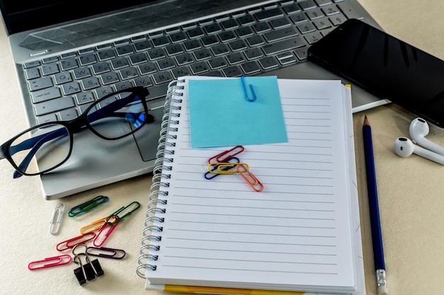 Foto concepto de negocio con portátil con portátil de papel de nota pequeña y suministros de oficina