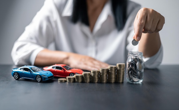 Concepto de negocio de seguros de automóvil que ahorra compra venta con impuestos y préstamo para automóvil nuevo Vehículo de juguete de automóvil con moneda de pila en segundo plano Planificación para administrar los costos de financiación del transporte préstamo para automóvil