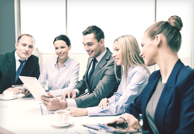 Concepto de negocio, tecnología y oficina: equipo de negocios sonriente con tableta, documentos y café que tienen una discusión en la oficina