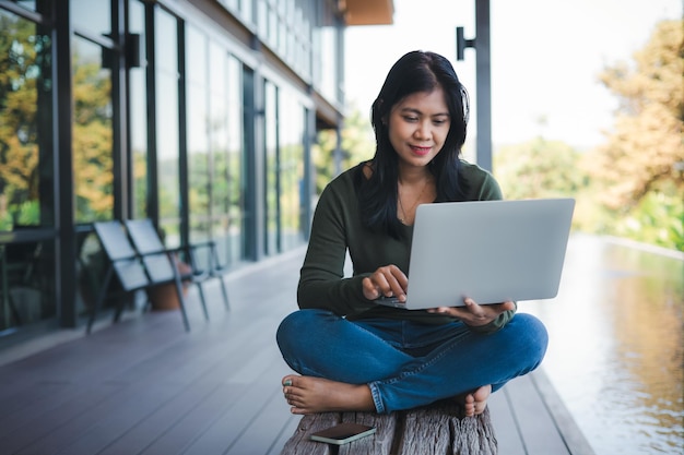 Concepto de negocio Trabajar lejos de la oficina Empresario analizando el gráfico de rendimiento de la empresa para generar ganancias y crecimiento Mujer de negocios escribiendo en el teclado de la computadora portátil en una cafetería