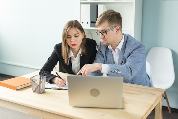 Concepto de negocio, trabajo en equipo y personas: hombre serio y mujer atractiva que trabaja en el proyecto en