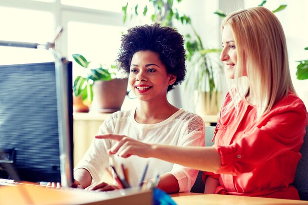 concepto de negocios, educación, puesta en marcha y personas: mujeres felices o estudiantes con computadora en la oficina