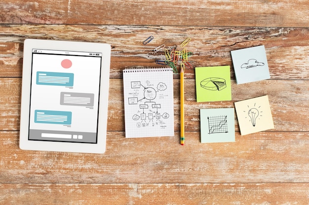 concepto de negocios, multimedia, objetos y tecnología: cierre de portátiles, tabletas y pegatinas en la mesa