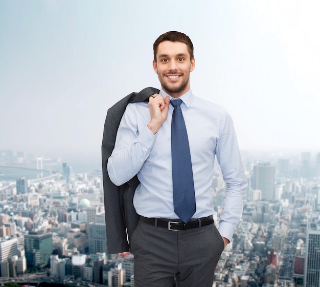 El concepto de negocios y personas: un joven y apuesto hombre de negocios sonriente sobre el fondo del paisaje urbano