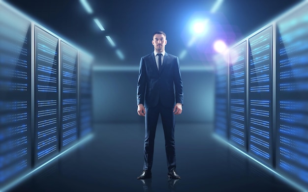 Concepto de negocios, personas y tecnología: hombre de negocios trajeado sobre el fondo de la sala de servidores