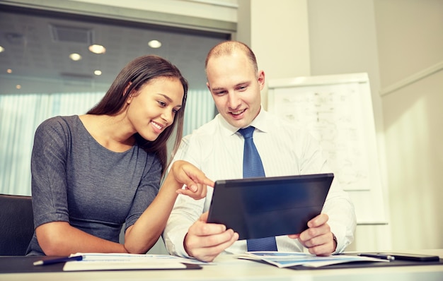 concepto de negocios, personas, tecnología y trabajo en equipo - hombre de negocios sonriente y mujer de negocios con una reunión de computadora de tablet pc en la oficina