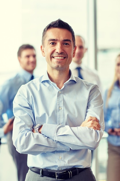 Foto concepto de negocios, personas y trabajo en equipo - hombre de negocios sonriente con un grupo de colegas en el cargo