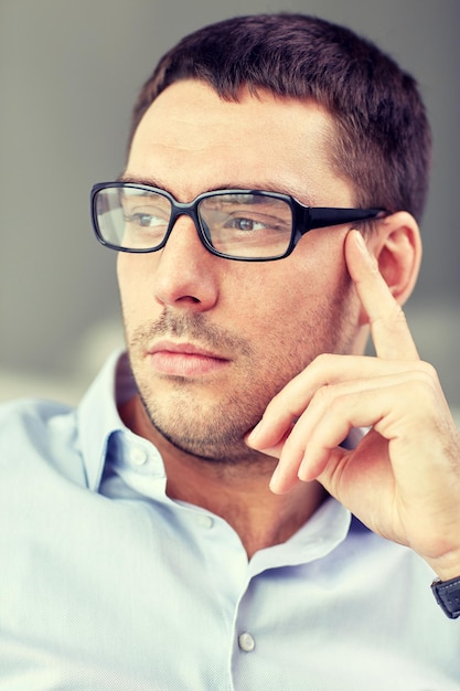 concepto de negocios, personas y trabajo - retrato de un hombre de negocios con anteojos en la oficina