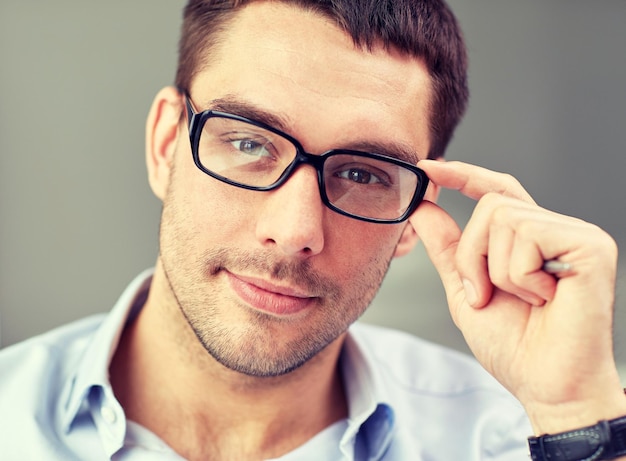 concepto de negocios, personas y trabajo - retrato de un hombre de negocios con anteojos en la oficina