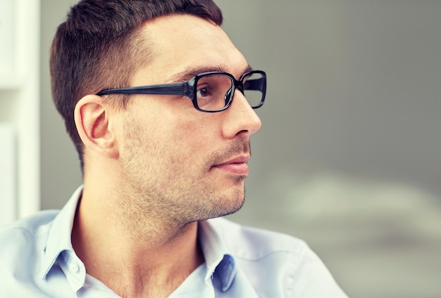 Foto concepto de negocios, personas y trabajo - retrato de un hombre de negocios con anteojos en la oficina