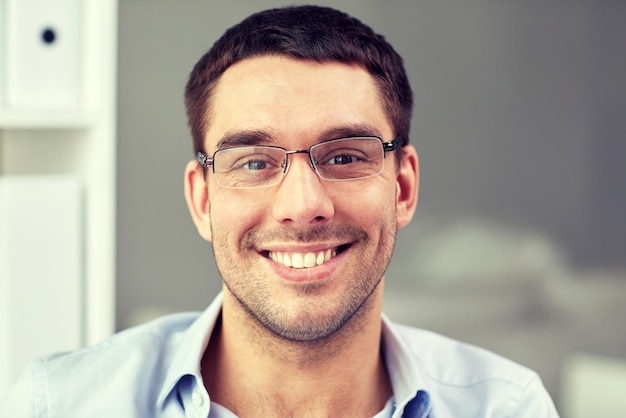 concepto de negocios, personas y trabajo - retrato de un hombre de negocios sonriente con anteojos en el cargo
