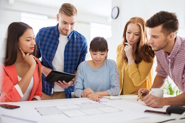 concepto de negocios, puesta en marcha, educación y personas: equipo de arquitectos creativos o estudiantes con planos que trabajan en la oficina