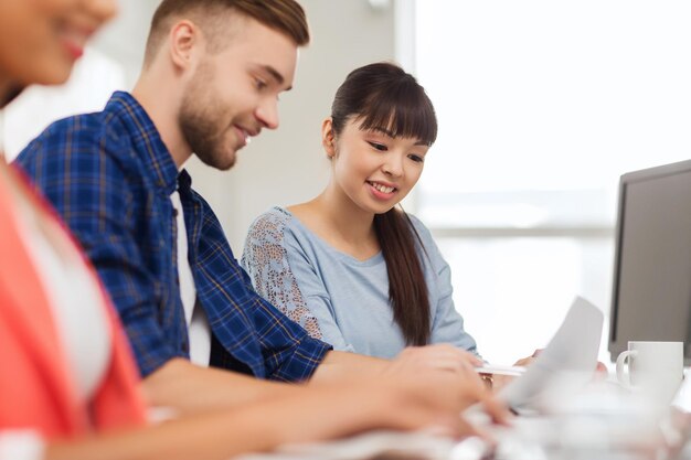 concepto de negocios, puesta en marcha, educación y personas: equipo creativo feliz o estudiantes que trabajan en la oficina