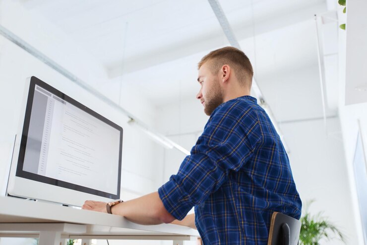Foto concepto de negocios, tecnología, educación y personas - joven creativo o programador con computadora trabajando en la oficina