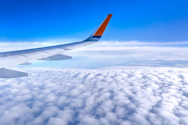 Concepto de negocios y viajes Vista aérea a través de la ventana dentro de la cabina del avión con hermoso cielo azul y nubes con vista superior del espacio de la copia de la luz del sol