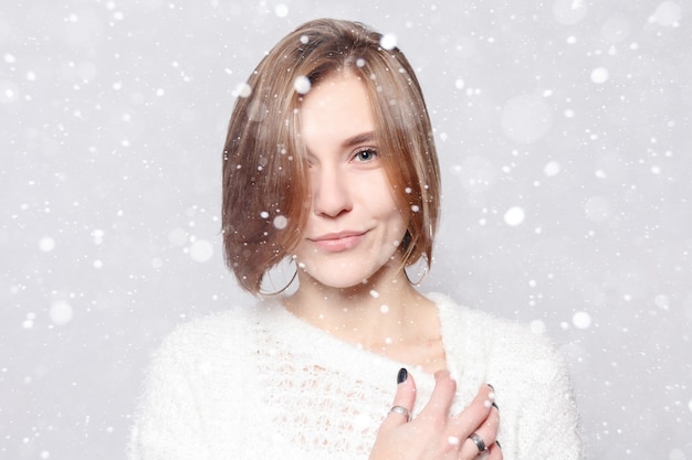 Concepto de nieve, invierno, Navidad, estilo de vida saludable, felicidad y personas - joven hermosa linda chica mostrando diferentes emociones. Riendo, sonriendo, enfado, sospecha, sorpresa. sobre fondo de nieve