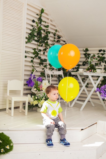 Concepto de niño, fiesta de cumpleaños y niñez - niño con globos en el interior.