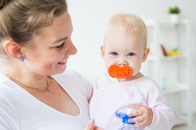 Concepto de niños y padres - madre y su pequeño bebé en casa de cerca