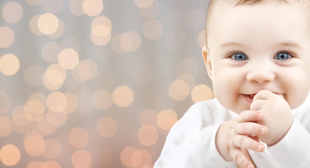 concepto de niños, personas, infancia y edad - hermoso bebé feliz durante las vacaciones luces de fondo