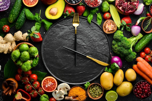 El concepto de nutrición dietética verduras y frutas frescas Cubiertos y un plato en forma de reloj Vista superior Espacio libre para su texto