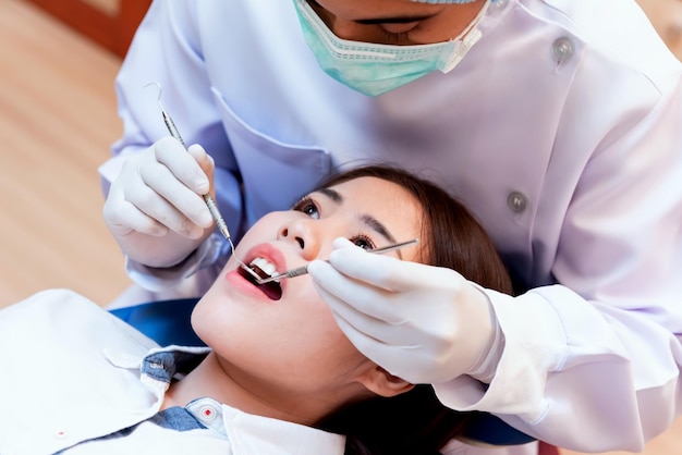 Concepto de odontología y atención médica en la clínica dental. Dientes de revisión de dentista para pacientes asiáticos jóvenes.