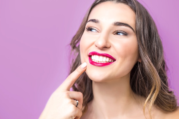 Concepto de odontologia Hermosa mujer joven sonriendo, mostrando dientes blancos sanos, labios rojos.