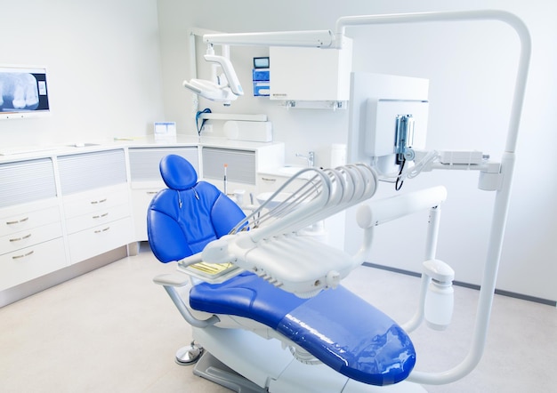 concepto de odontología, medicina, equipo médico y estomatología - interior de la nueva oficina de clínica dental moderna con silla