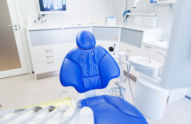 concepto de odontología, medicina, equipo médico y estomatología - interior de la nueva oficina de clínica dental moderna con silla