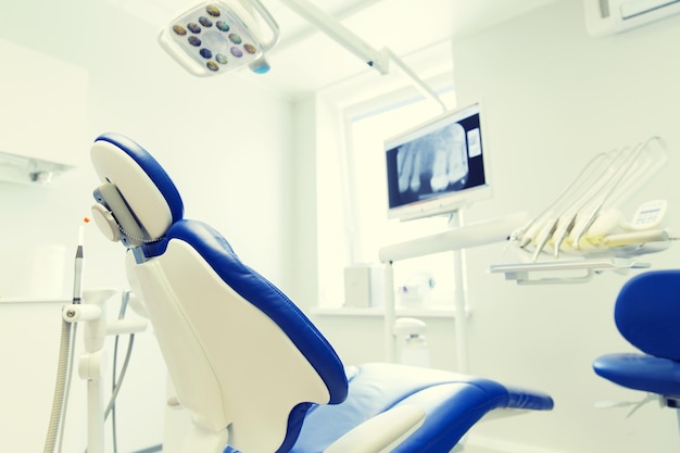 concepto de odontología, medicina, equipo médico y estomatología - interior de la nueva oficina de clínica dental moderna con silla