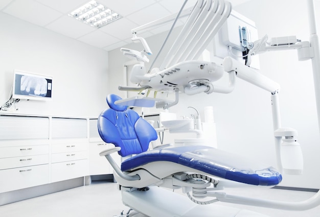 concepto de odontología, medicina, equipo médico y estomatología - interior de la nueva oficina de clínica dental moderna con silla