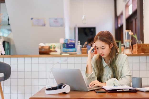 Concepto de oficina espacial de coworking Mujer empresaria estresante mientras lee datos comerciales en una computadora portátil