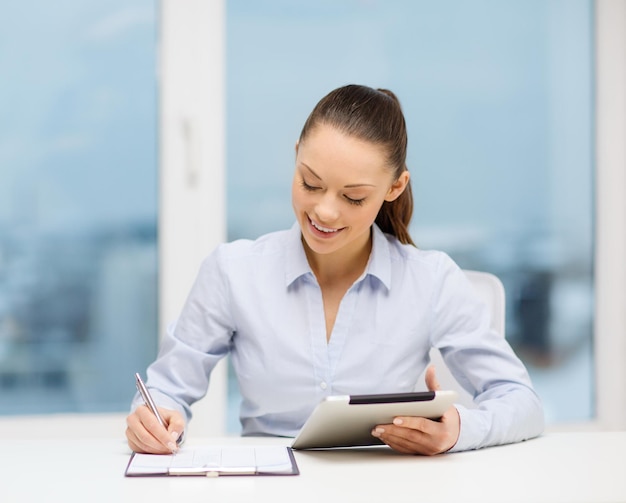 concepto de oficina, negocios, tecnología e Internet - mujer de negocios con tablet pc y documentos en la oficina