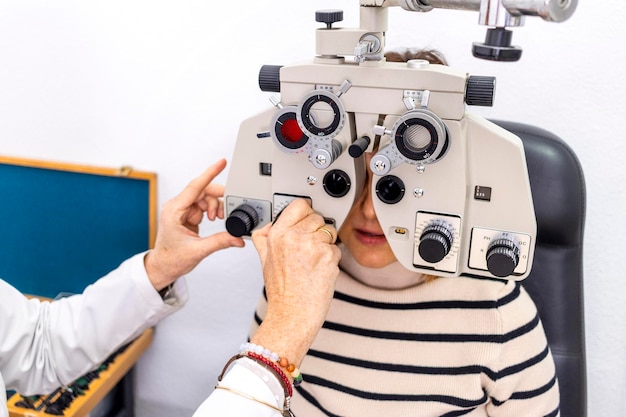 Concepto de optometría bastante joven teniendo sus ojos examinados por un oftalmólogo