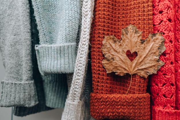 Concepto de otoño Caída de la hoja de arce en forma de corazón en un suéter cálido y acogedor Suéteres de lana y mohair de punto estilo Hygge