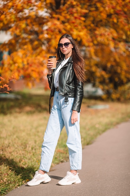 Concepto de otoño - hermosa mujer en otoño parque bajo follaje de otoño